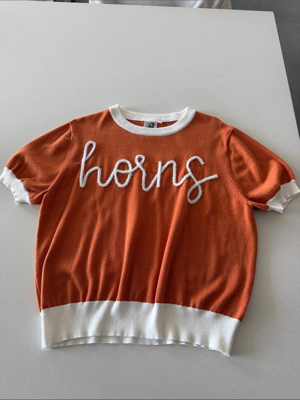 QUEEN OF SPARKLES Orange Knit Tee with White Trim and 'horns' Script